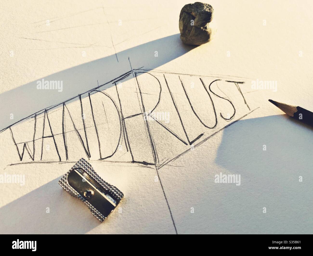 Nahaufnahme meines Skizzenbuchs. Üben von Handschriftendruck und Typografie während einer Grafikdesign-Studienstunde. Skizzieren und Zeichnen. Fernweh Konzept. Grobe Skizze auf Papier mit Bleistift und Radiergummi - Smartphone-aufgenommenes Stockfoto