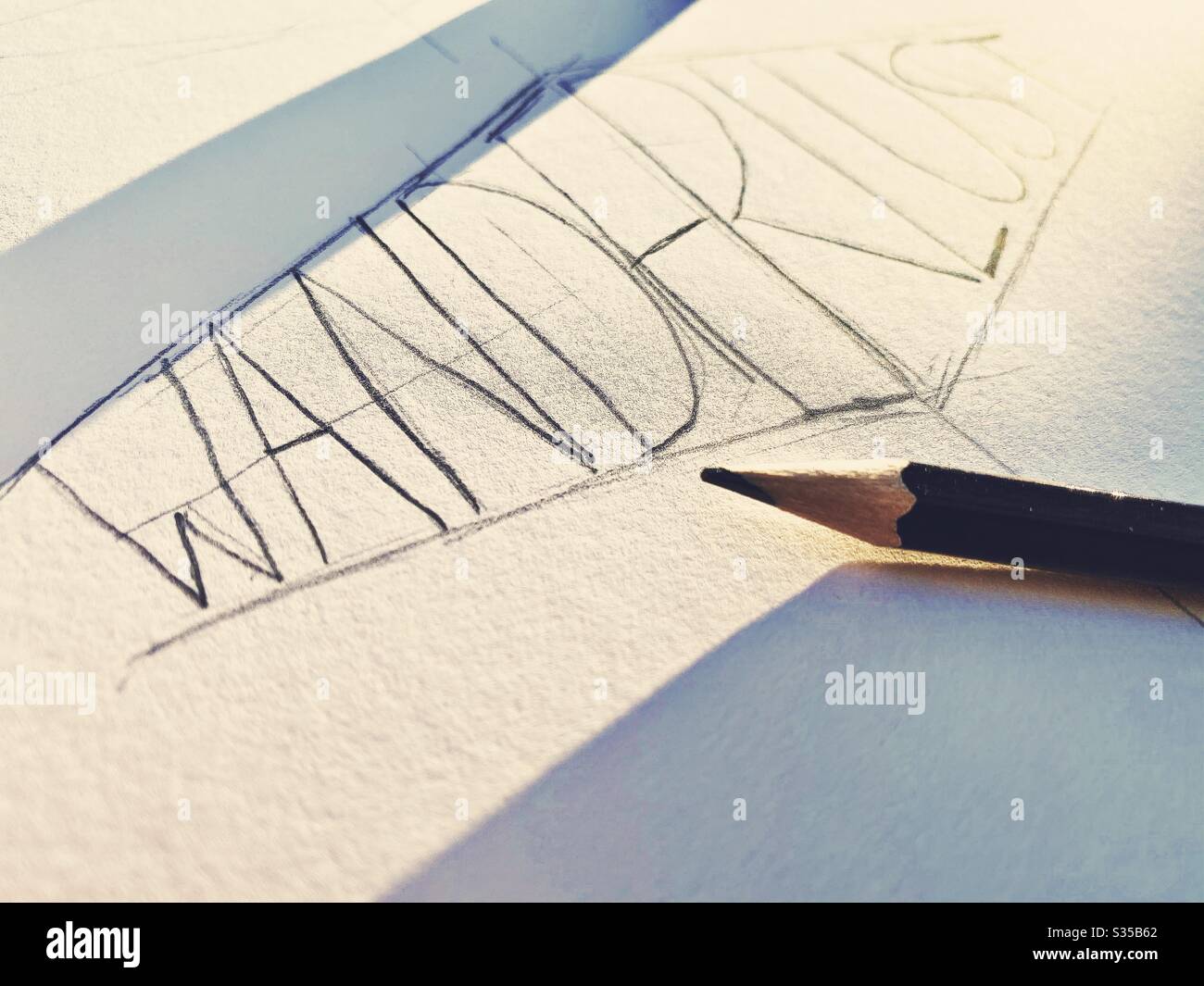 Nahaufnahme meines Skizzenbuchs. Üben von Handschriftendruck und Typografie während einer Grafikdesign-Studienstunde. Skizzieren und Zeichnen. Fernweh Konzept. Grobe Skizze auf Papier mit Bleistift und Radiergummi - Smartphone-aufgenommenes Stockfoto