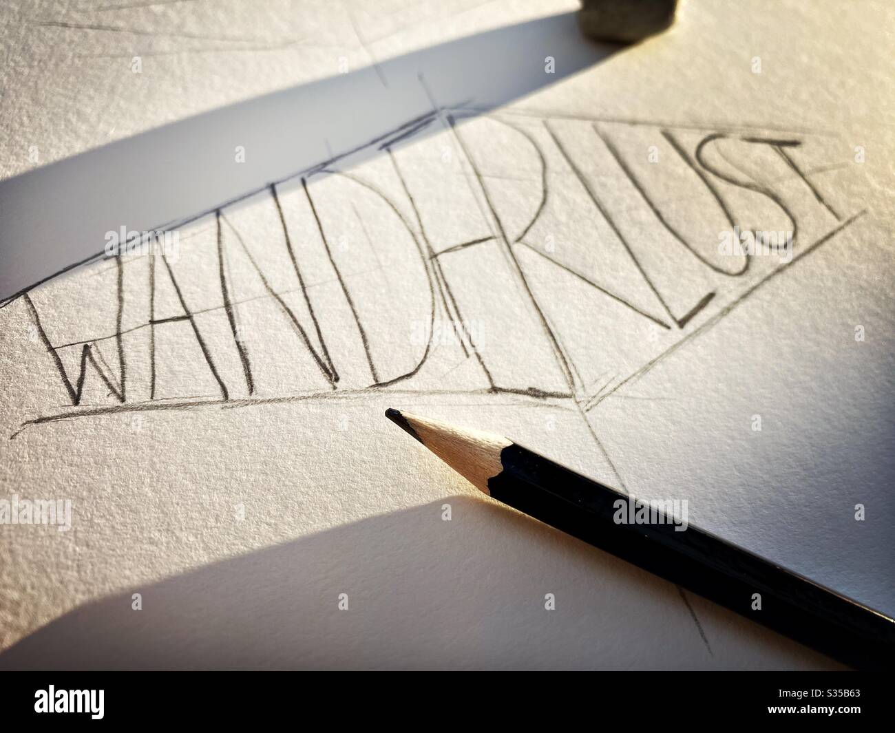 Nahaufnahme meines Skizzenbuchs. Üben von Handschriftendruck und Typografie während einer Grafikdesign-Studienstunde. Skizzieren und Zeichnen. Fernweh Konzept. Grobe Skizze auf Papier mit Bleistift und Radiergummi - Smartphone-aufgenommenes Stockfoto