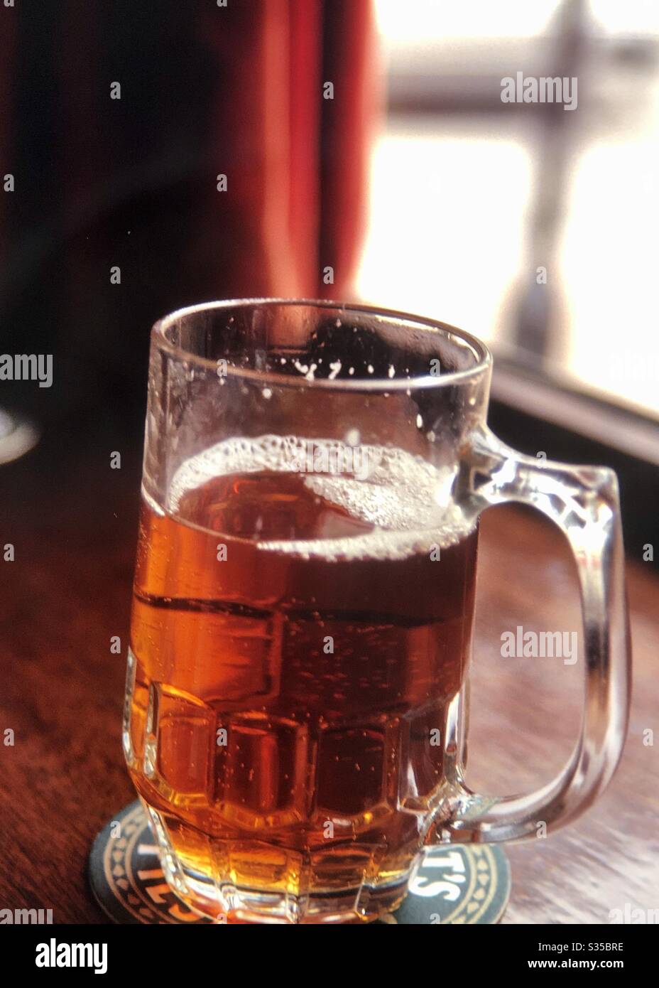 Einzelbecher mit Bier im Pub-Fenster von London England Stockfoto