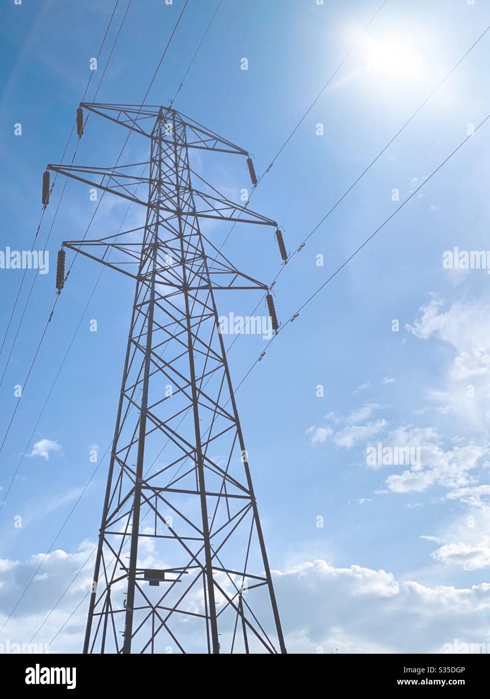 Strommast mit blauem Himmel und Sonneneinstrahlung. Stromkabel. Stromversorgungsnetz. Stromausschaltung. Energiepreise Stockfoto