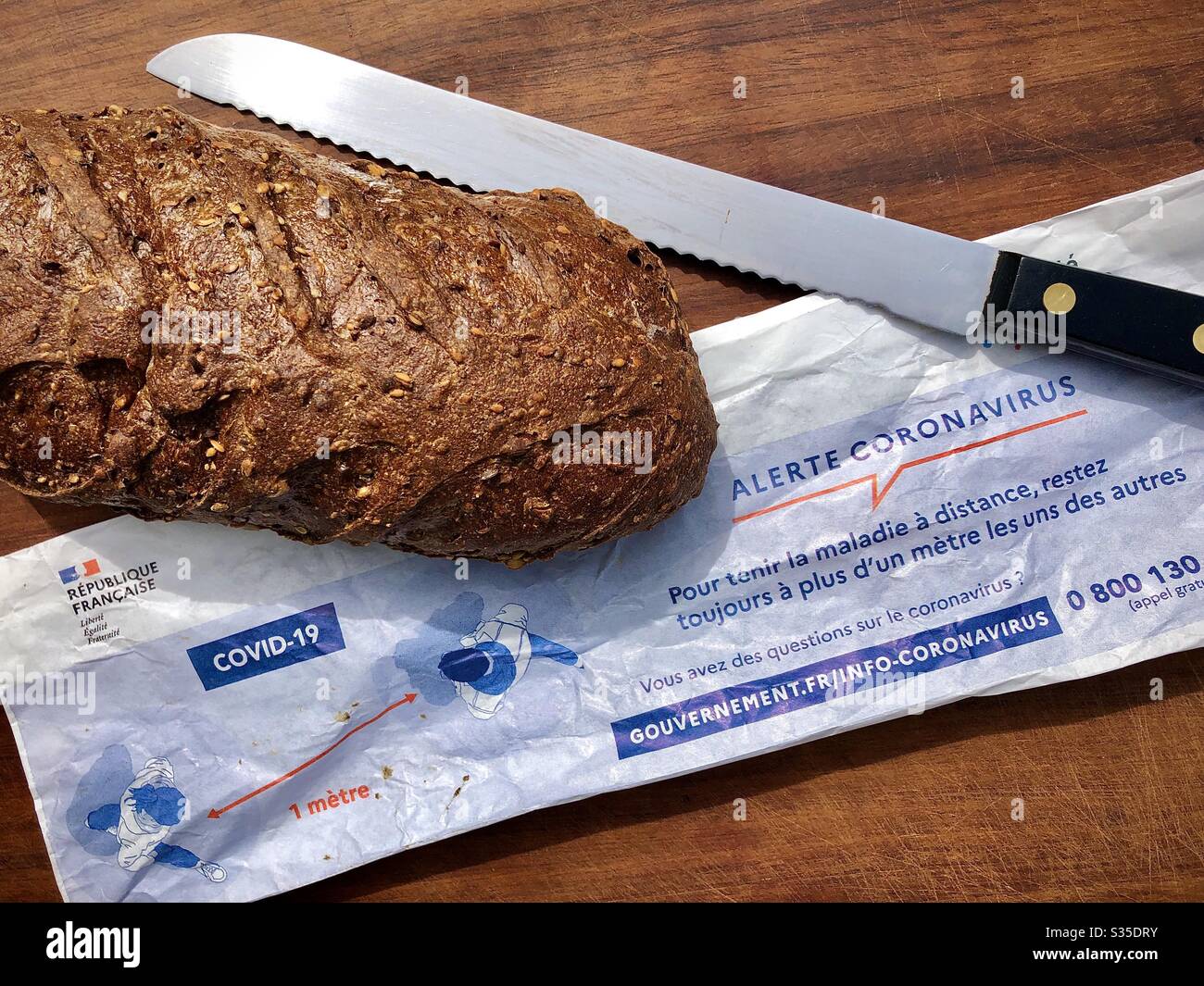 Papiertüte für französisches Brot mit aufgedrucktem Coronavirus Warnhinweis und Anleitung in Frankreich. Stockfoto