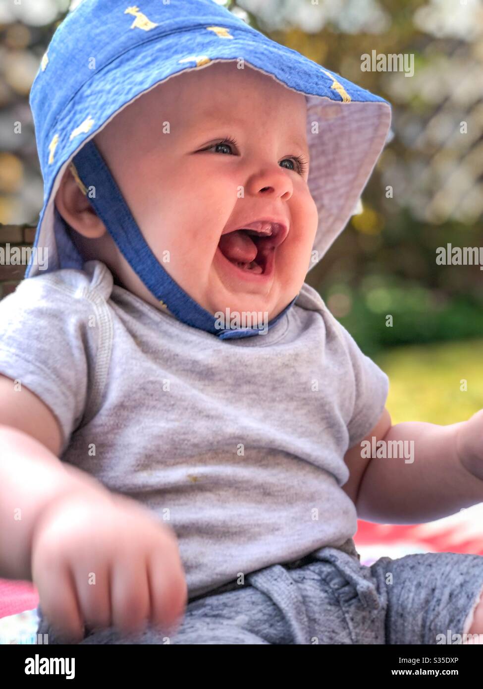 Lachendes Baby im Garten - Smartphone-aufgenommenes Stockfoto