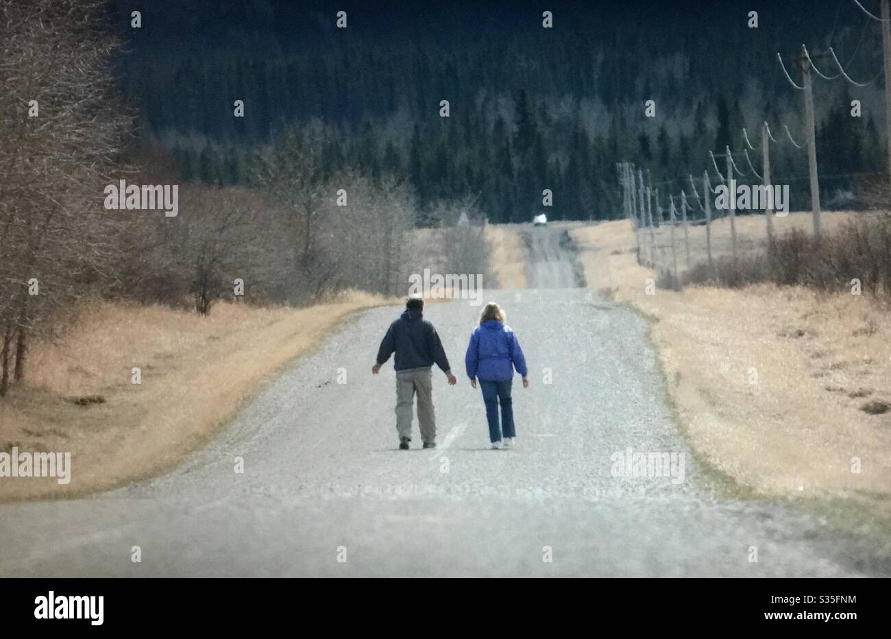 Zwei Leute gehen auf einer Schotterstraße spazieren. Stockfoto