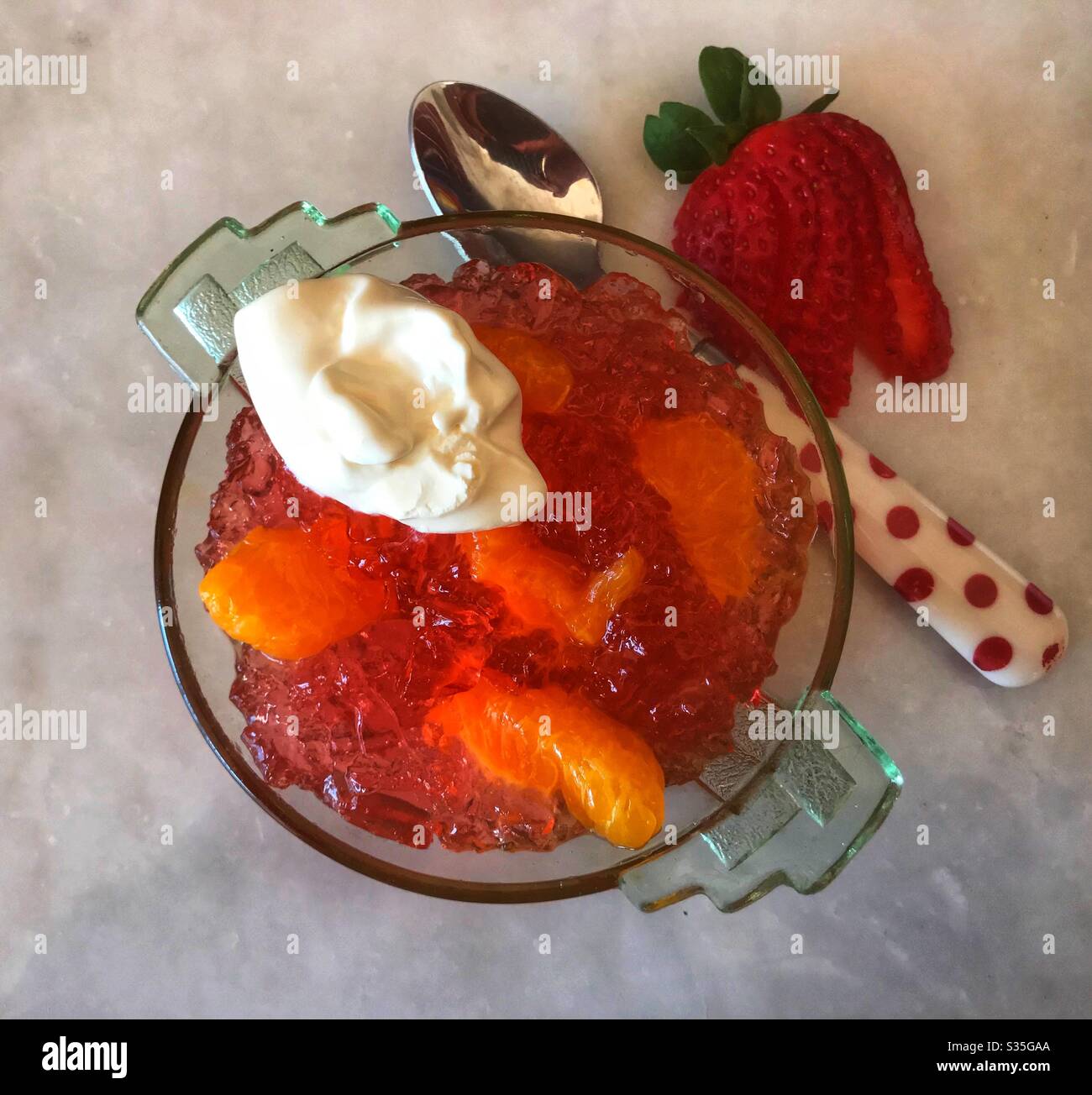 Erdbeergelee mit Mandarinorangen und extra dicker Doppelcreme. Stockfoto