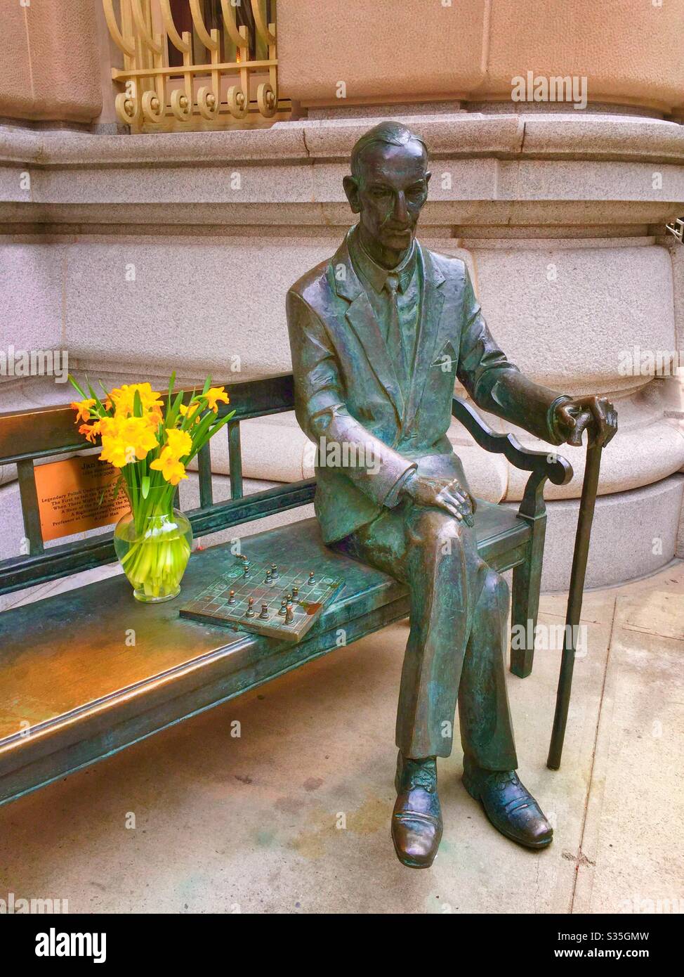 Statue von Lech Kaczynski vor dem polnischen Generalkonsulat in Midtown Manhattan zusammen mit einer Vase aus Narzissen, Frühling, NYC, USA - Smartphone-aufgenommenes Stockfoto