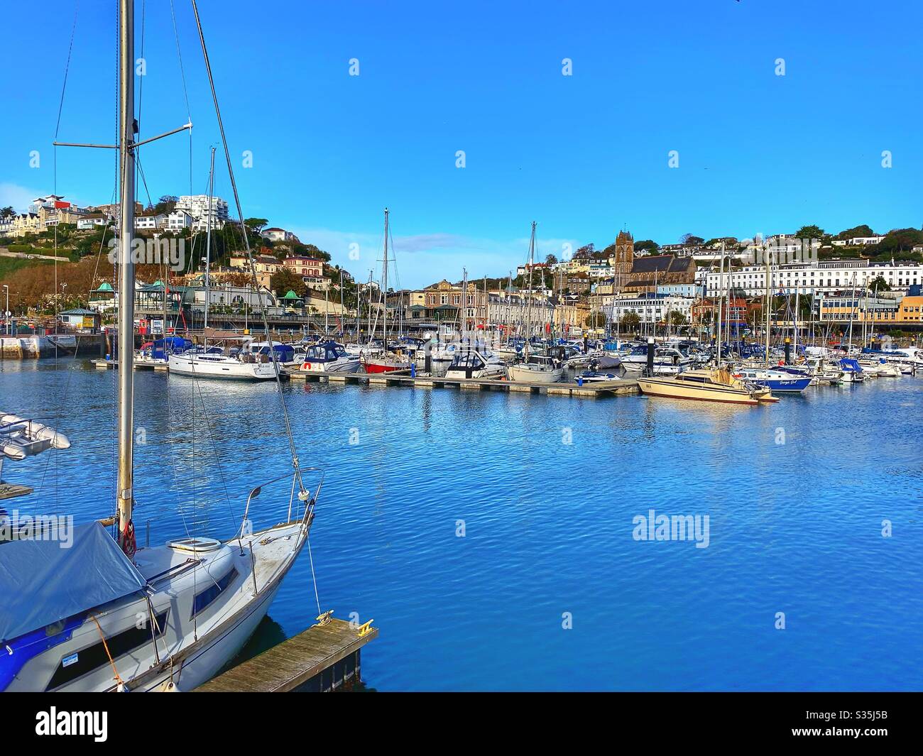 Torquay Harbour an einem sonnigen Tag mit blauem Himmel und vielen Vergnügungsbooten. Stockfoto
