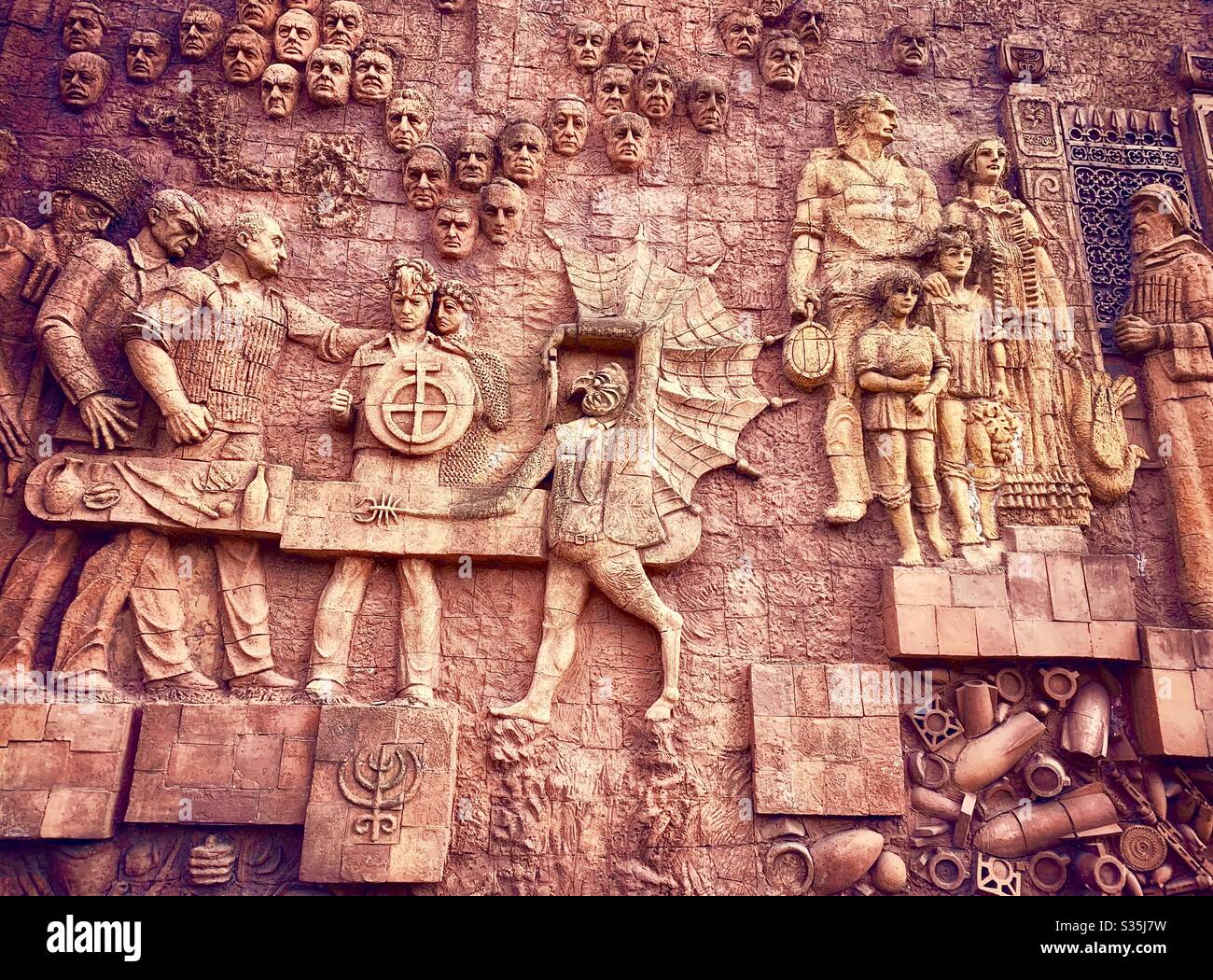 Die geschnitzte Außenwand des Kutaissi-Marktes, die die Geschichte ihrer Nation darstellt. Kutaissi, Georgien. - Smartphone-aufgenommenes Stockfoto