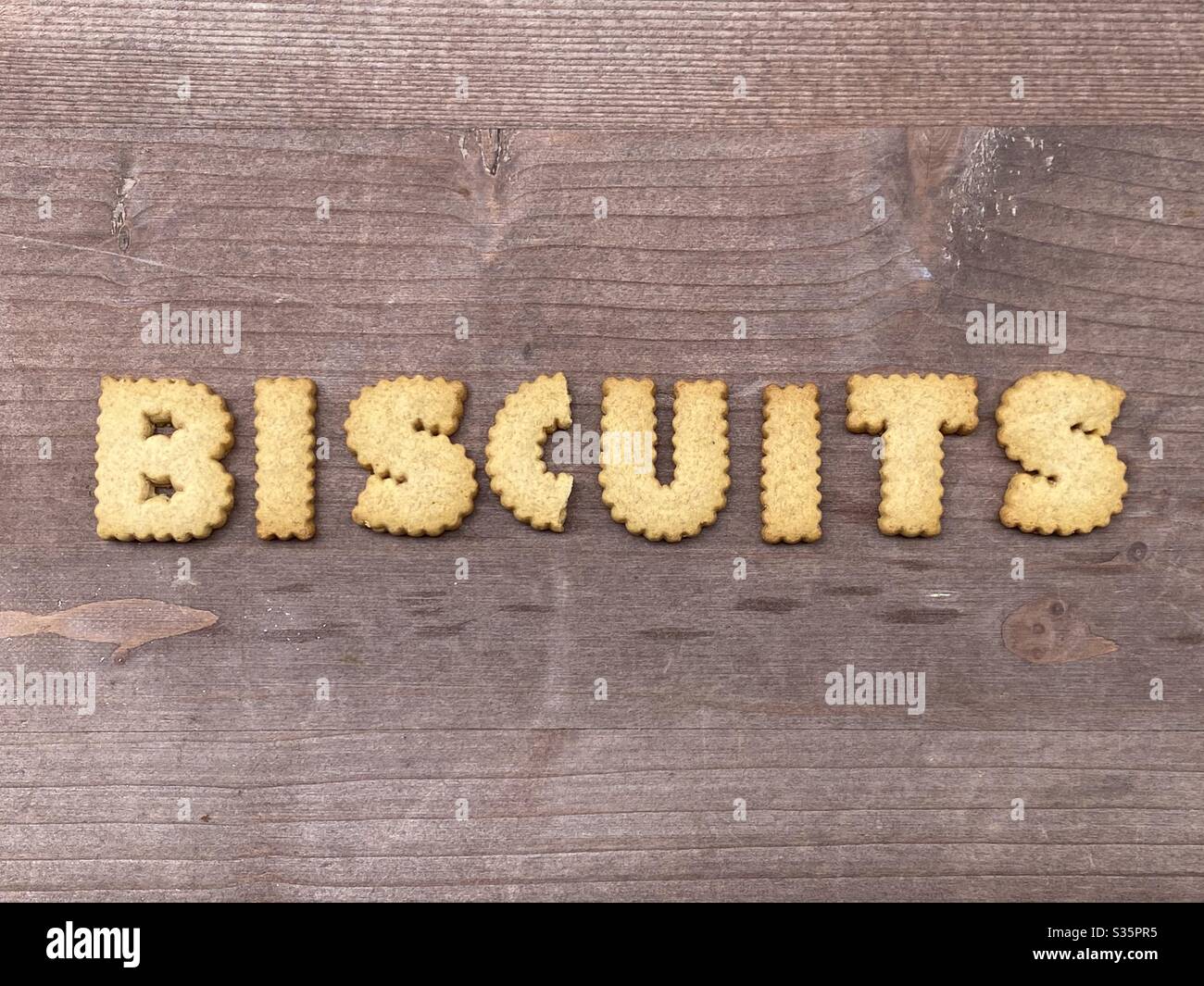 Biscuits Wort mit Cookie Buchstaben über einem Holzbrett Stockfoto