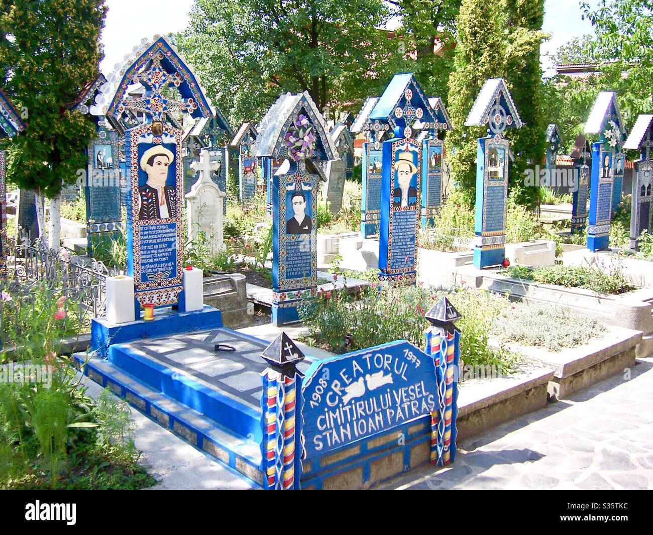 Grab des Schöpfers des fröhlichen Friedhofs (Stan Ioan Pătraș) in Săpânța, Maramureș berühmt für seine bunten Grabsteine mit naiven Gemälden und poetischen weißen Epitafs, Rumänien 🇷🇴 Stockfoto