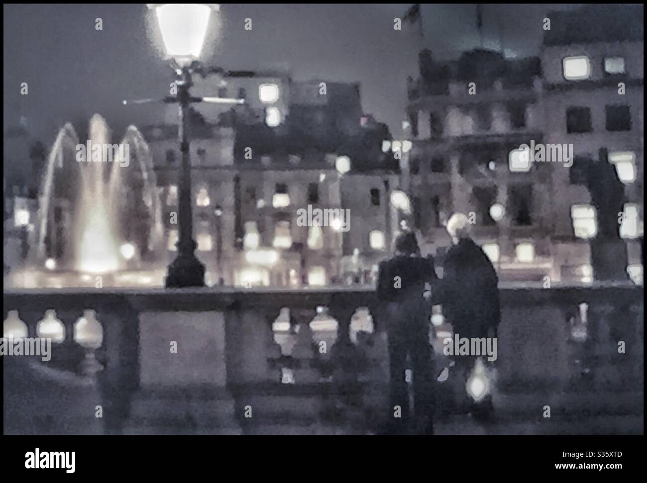 Ein Paar, das abends am Trafalgar Square ist. - Smartphone-aufgenommenes Stockfoto