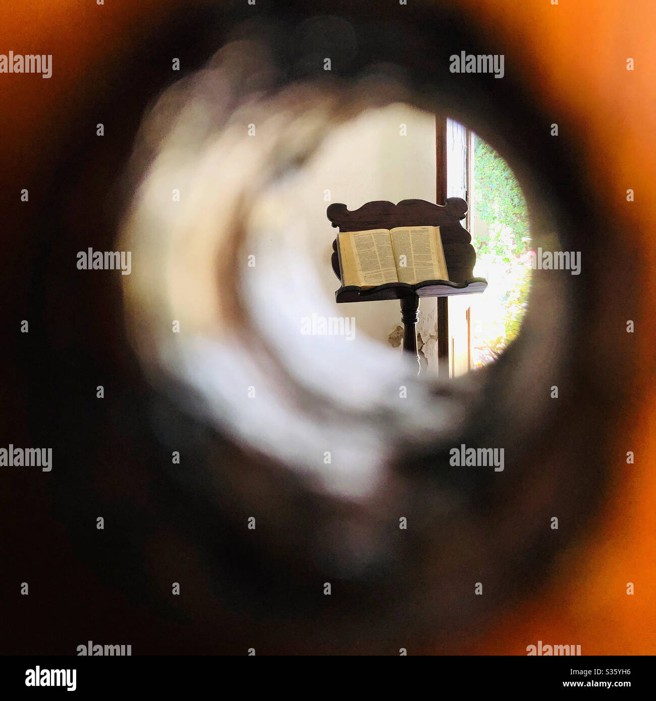 Blick durch ein Guckloch in einen Kirchenhof. Stockfoto