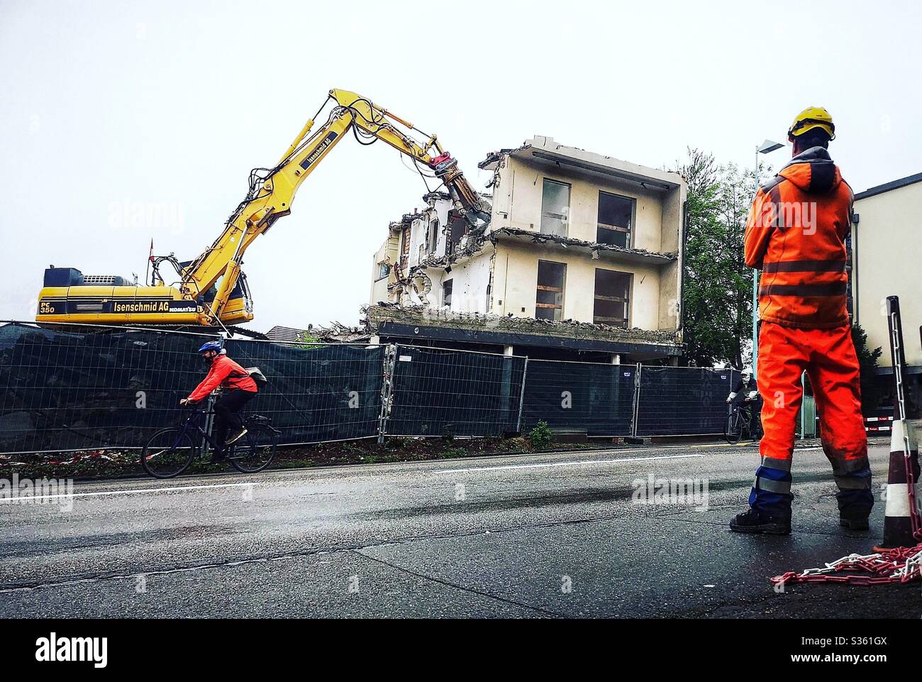 Gebäude wird abgerissen, wie Arbeiter sieht - Smartphone-aufgenommenes Stockfoto