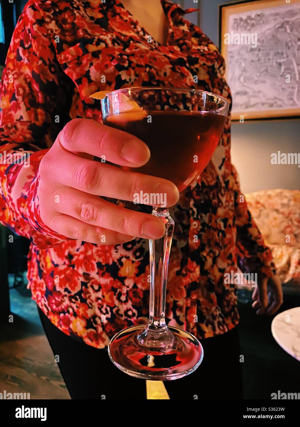 Nahaufnahme einer Frau, die einen Cocktail hält - Smartphone-aufgenommenes Stockfoto