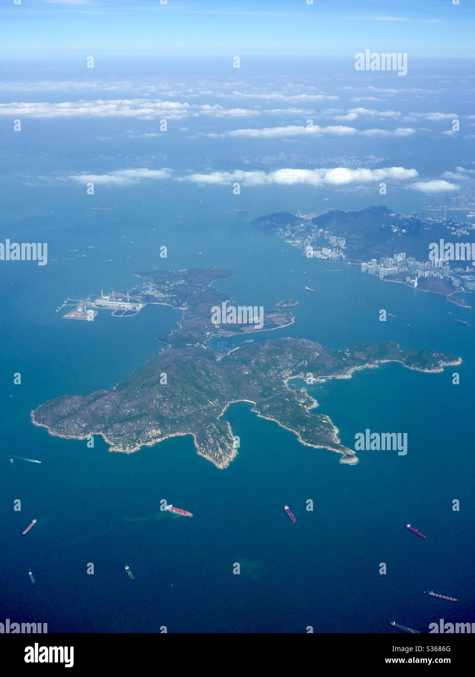 Luftbild von Lamma Island und Lamma Island Power Station mit Hong Kong Island im Hintergrund. Stockfoto