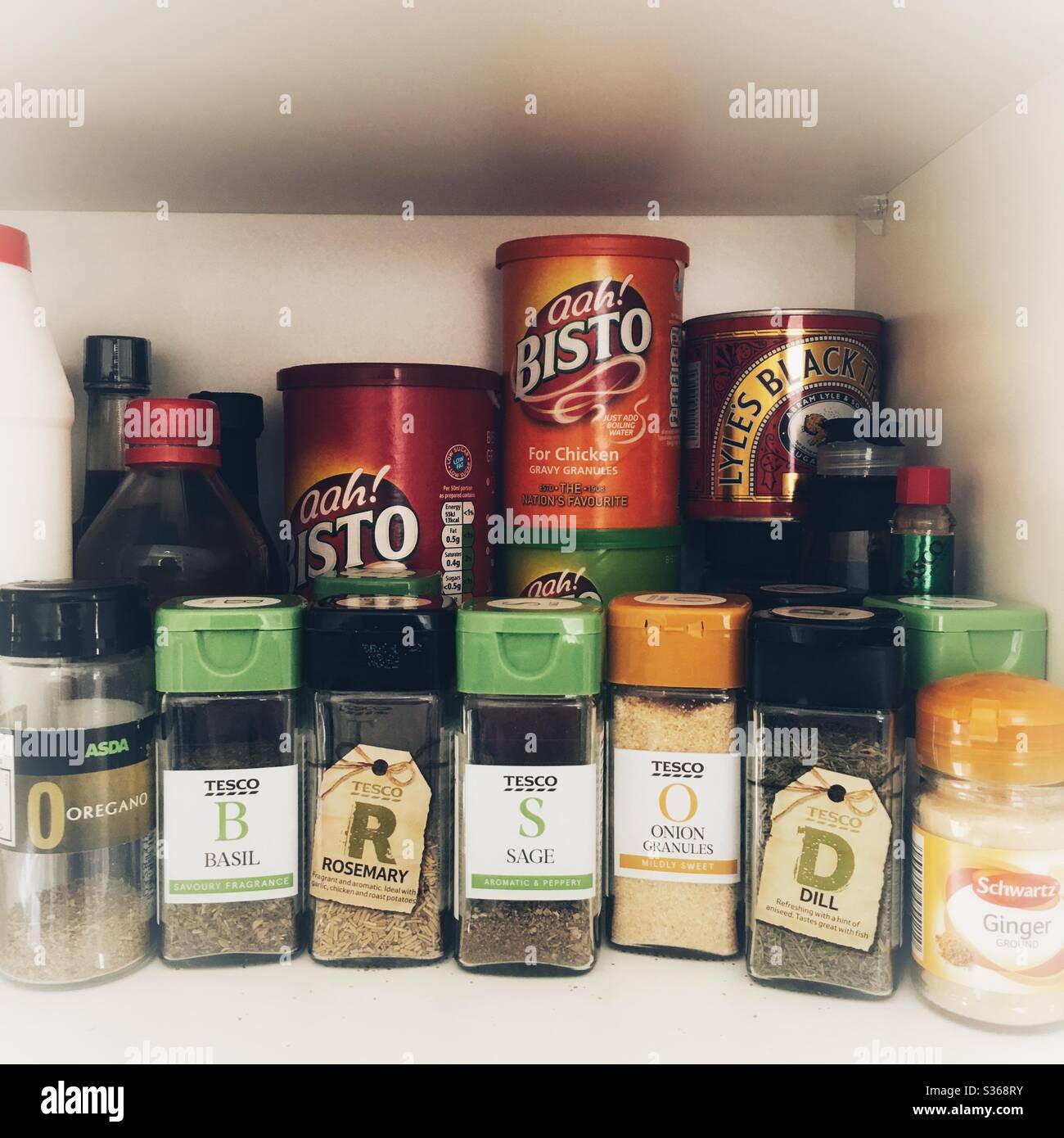 Ein Foto von einem Küchenschrank Regal voller Marken Kräuter und Gewürze, Soße, Treakel und Saucen. Zutaten für die Hausmannskost. - Smartphone-aufgenommenes Stockfoto