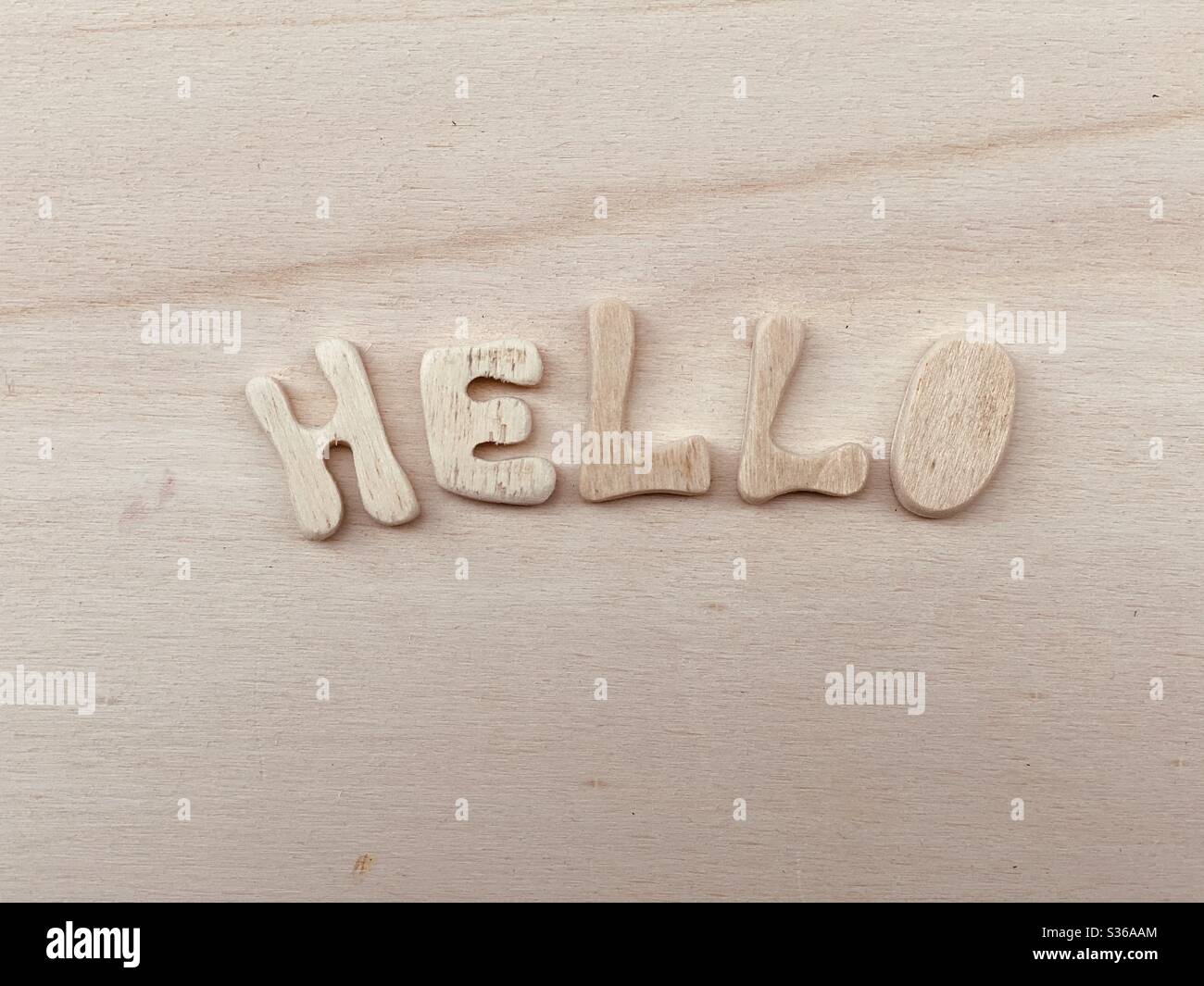 Hello Text mit handgefertigten Holzbuchstaben auf einem Holzbrett komponiert - Smartphone-aufgenommenes Stockfoto
