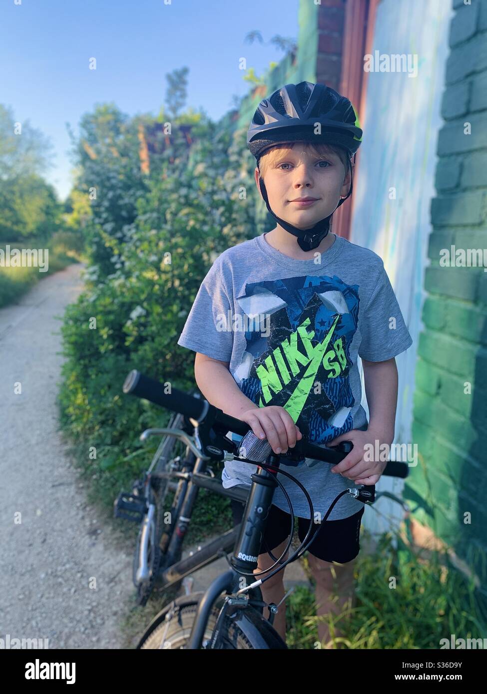 Porträt eines Jungen und seines Fahrrads Stockfoto