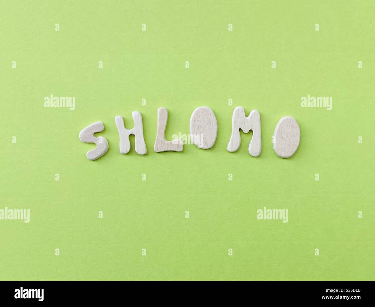 Shlomo, gemeinsame hebräische männliche Vorname mit handgefertigten Holzbuchstaben über grüne Farbe zusammengesetzt Stockfoto