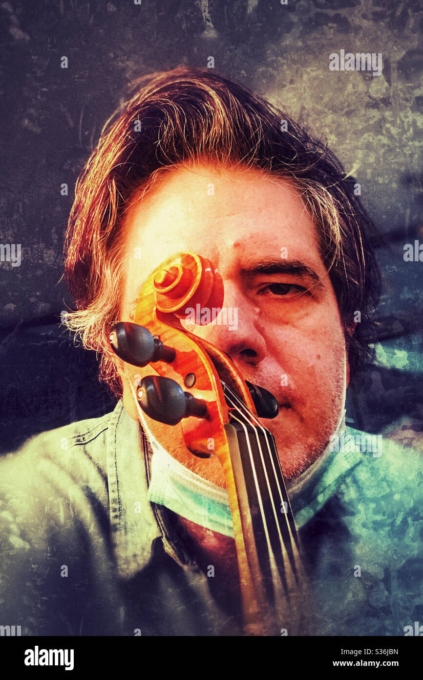 Mann-Portrait mit Geige und Gesichtsmaske Stockfoto