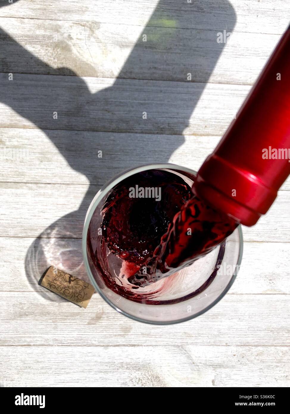 Rotwein wird in ein Glas gegossen Stockfoto