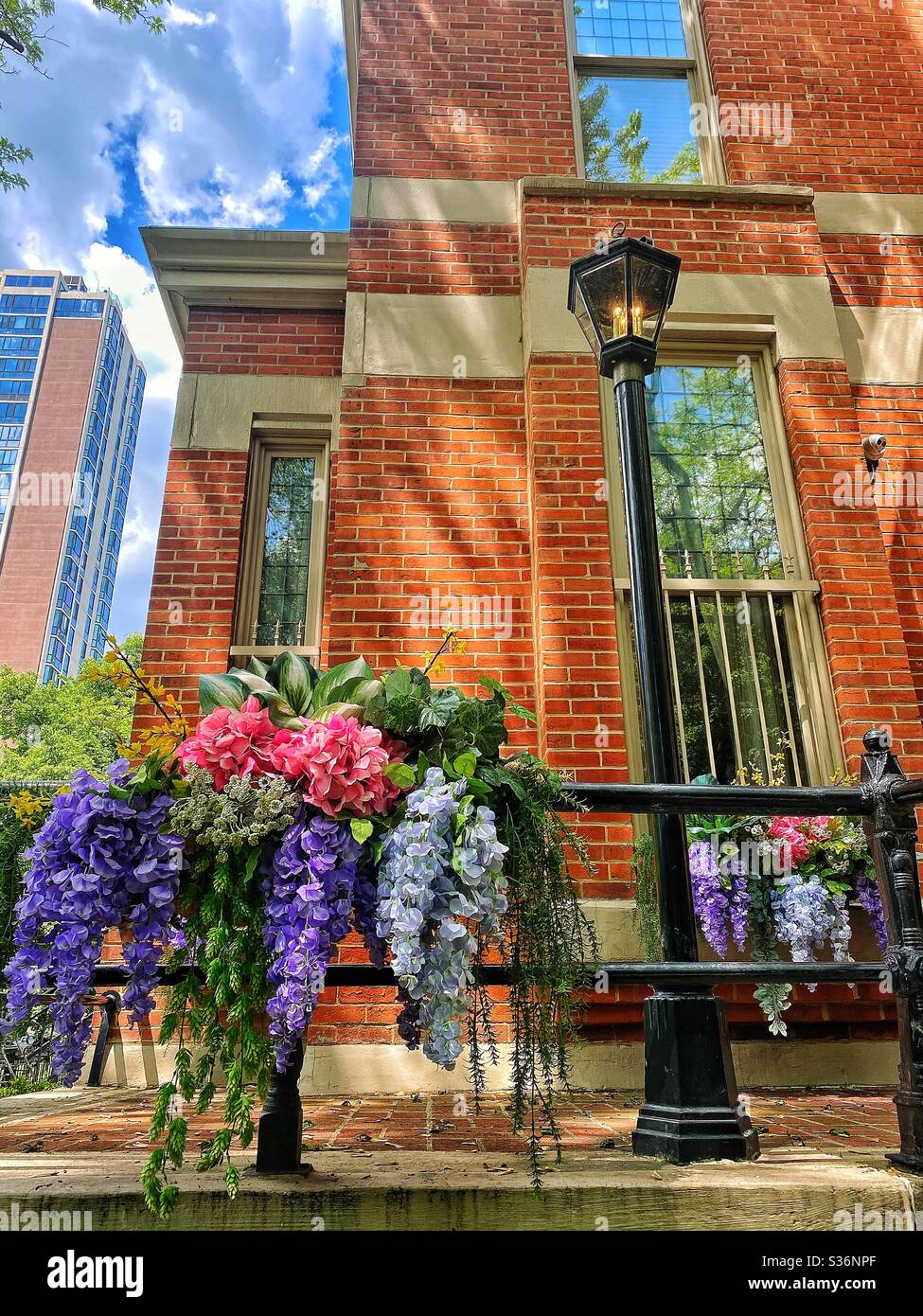 Hübsche bunte Blumentopf hängen außerhalb eines Backsteinhauses, Chicago, Illinois Stockfoto