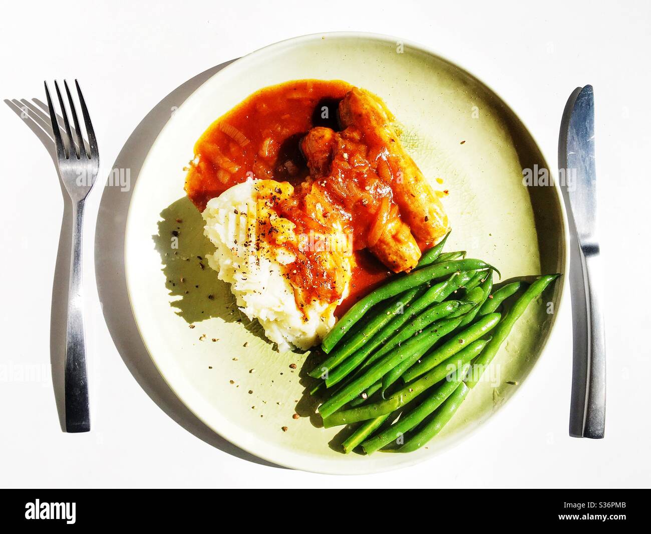 Wurst und Kartoffelpüree mit grünen Bohnen und Zwiebelsoße - Smartphone-aufgenommenes Stockfoto