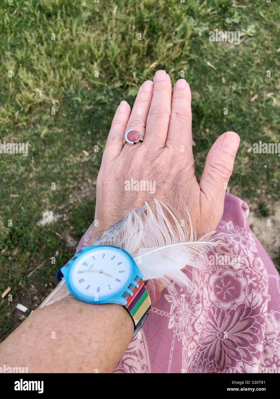 Eine weibliche Hand auf dem Knie. - Smartphone-aufgenommenes Stockfoto