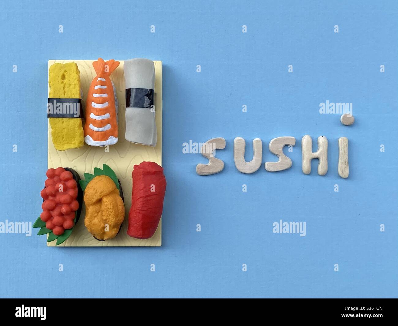 Sushi Poster Idee mit handgefertigten Holzbuchstaben und handgefertigten Sushi über blaue Farbe - Smartphone-aufgenommenes Stockfoto