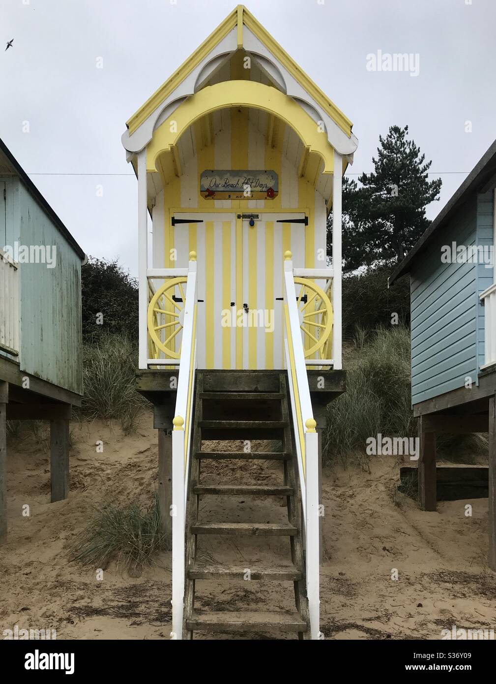 Ziemlich gelb und weiß am Meer stelzener Strandhütte in Wells-next-the-Sea, Norfolk, Großbritannien Stockfoto