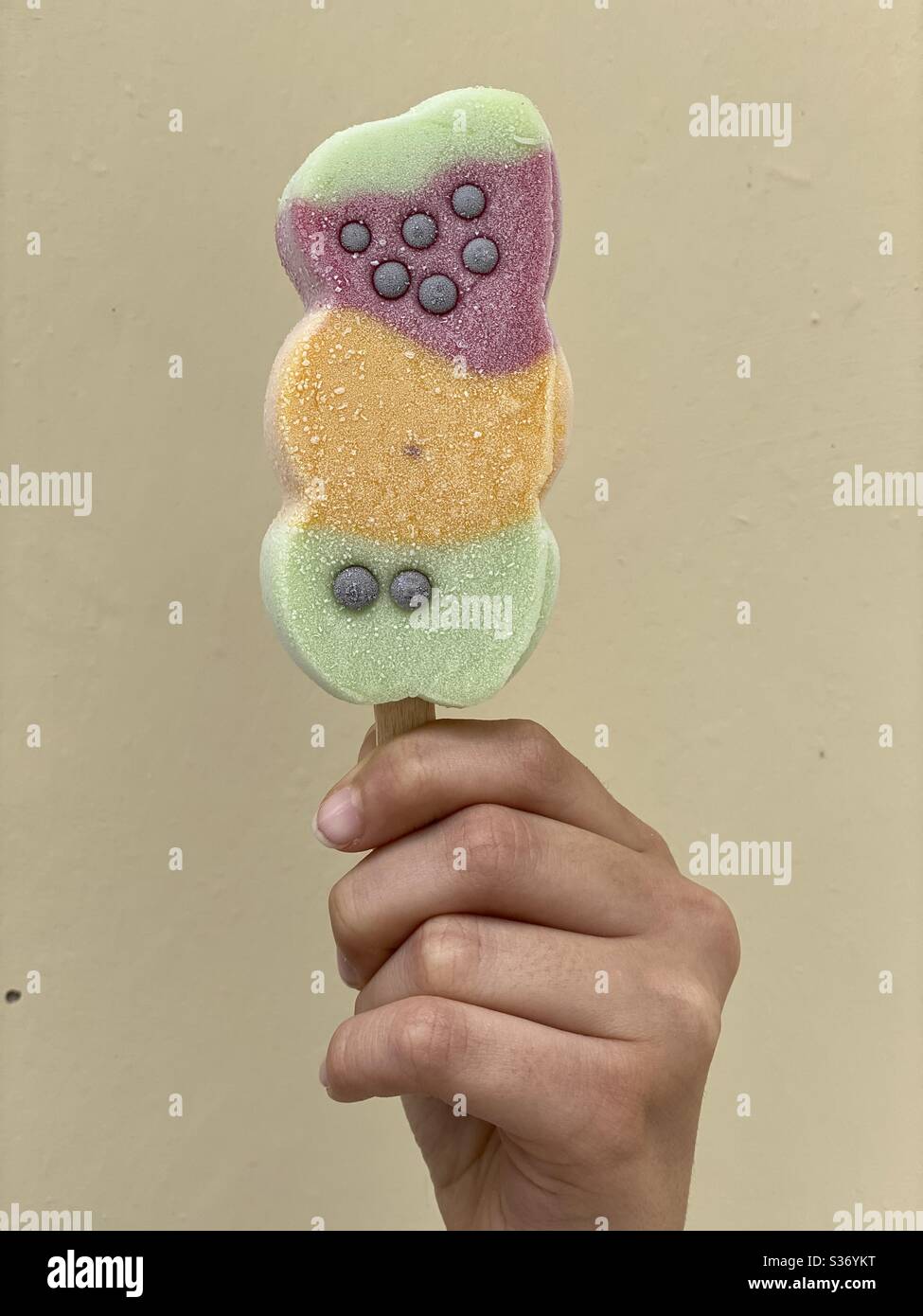 Baby Mädchen Hand hält ein buntes Eis - Smartphone-aufgenommenes Stockfoto
