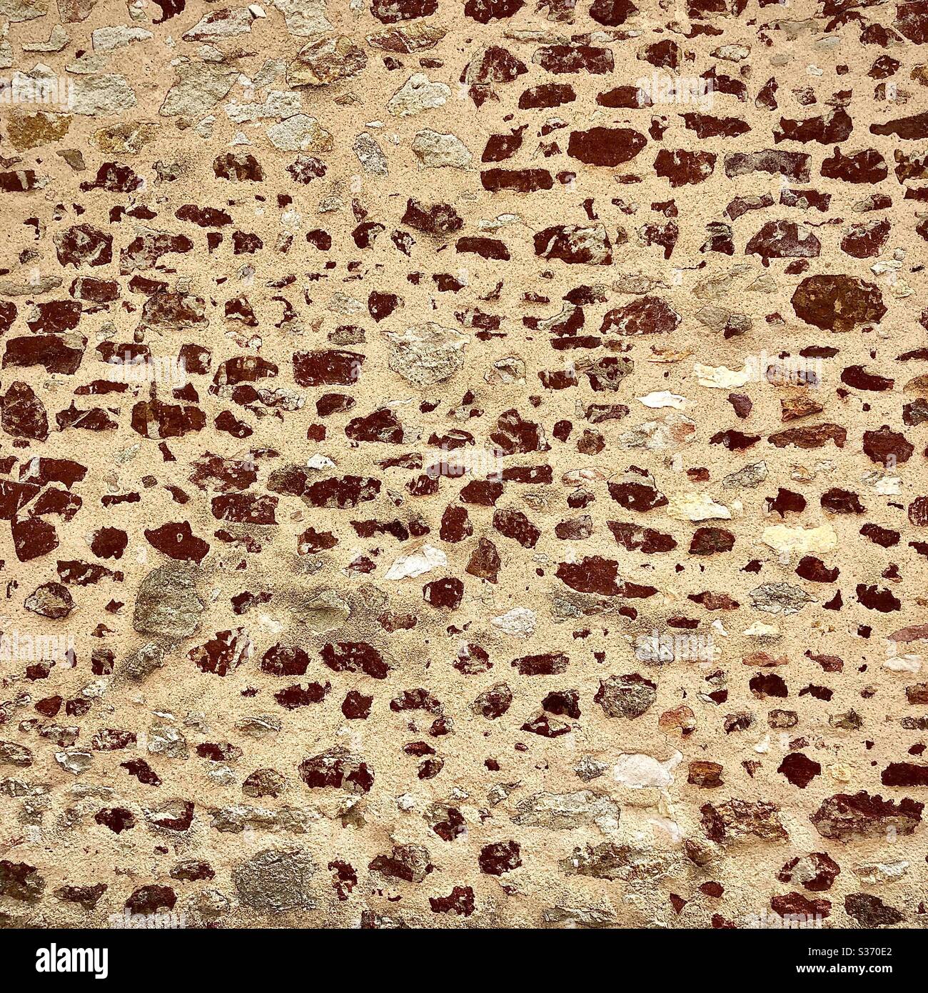 Alte zufällige Steinmauer mit rotem Eisengehalt in lokalem Gestein, Brenne, Indre, Frankreich. - Smartphone-aufgenommenes Stockfoto