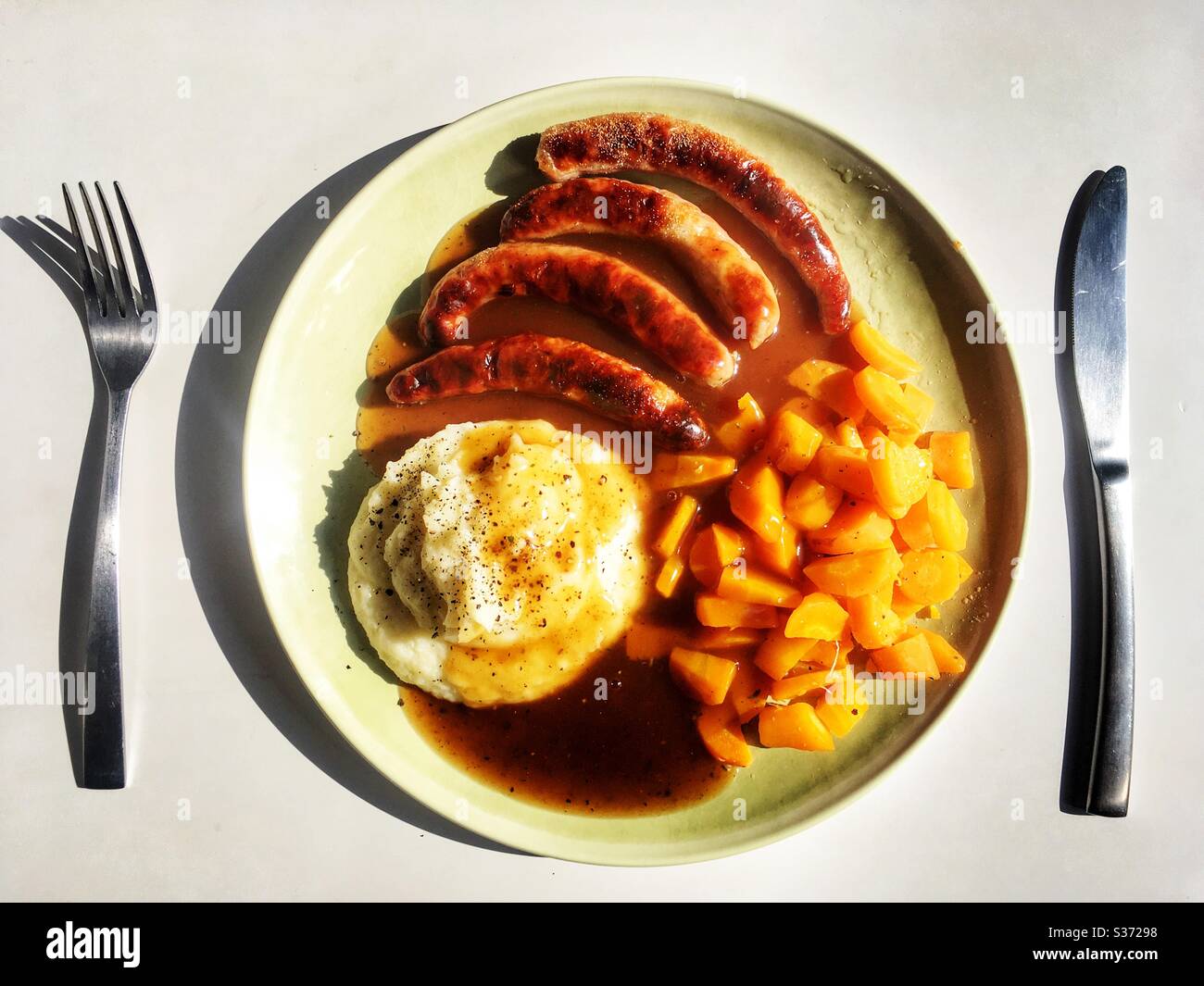 Chipolatas Kartoffelpüree Karotten und Soße - Smartphone-aufgenommenes Stockfoto