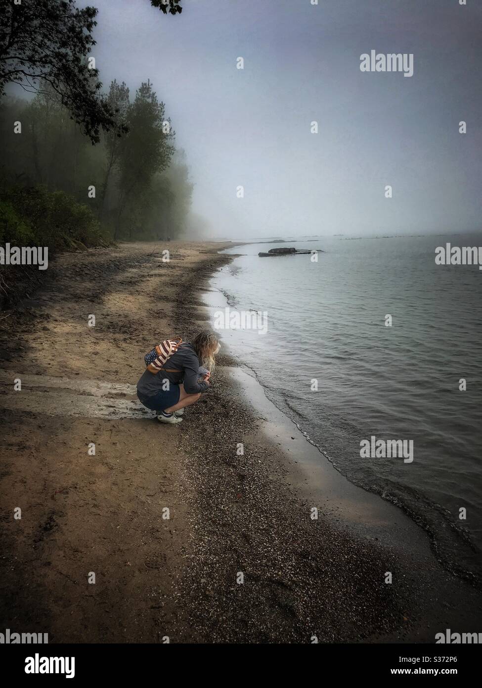 Frau sammelt Strandglas an der Küste des Eriesees Stockfoto