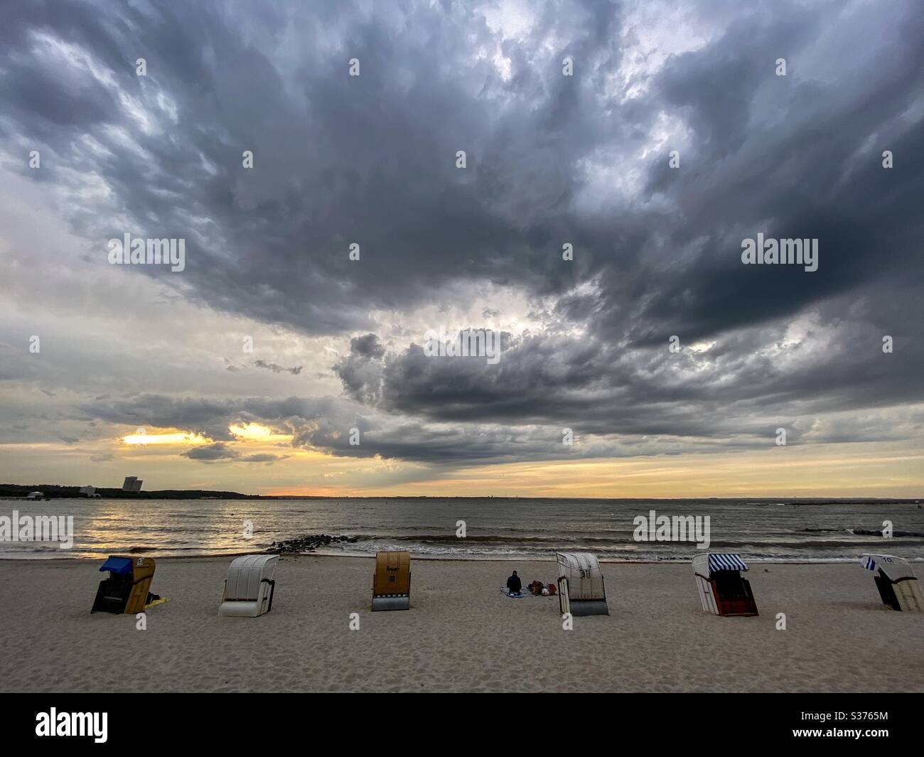 Dramatischer Himmel über einem Strand bei Sonnenuntergang in der Nähe der Ostsee - Smartphone-aufgenommenes Stockfoto