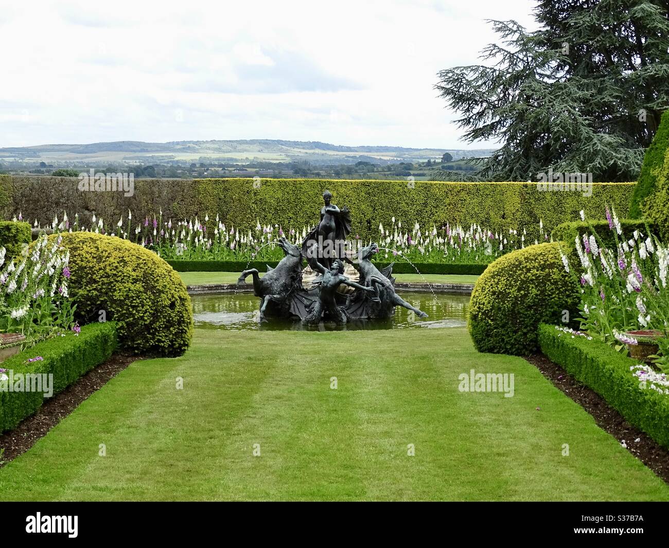 Panoramablick auf die englische Landschaft vom Ascott Estate Garten mit einem Brunnen im Vordergrund Stockfoto