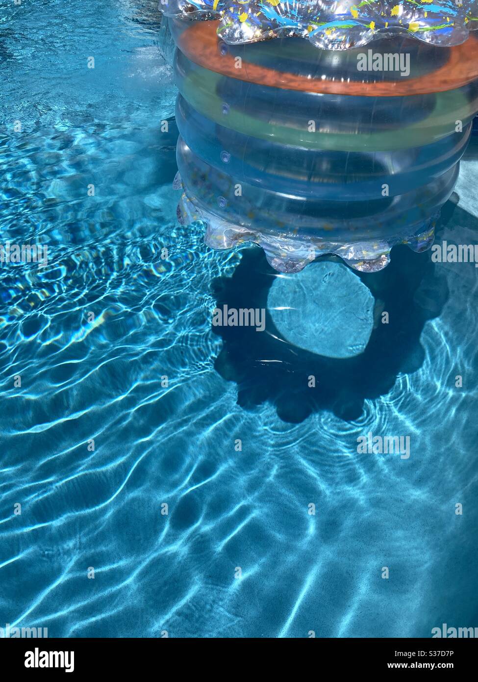 Farbenfrohe Schwimmbäder schaffen einen Schatten auf dem Wasser Stockfoto