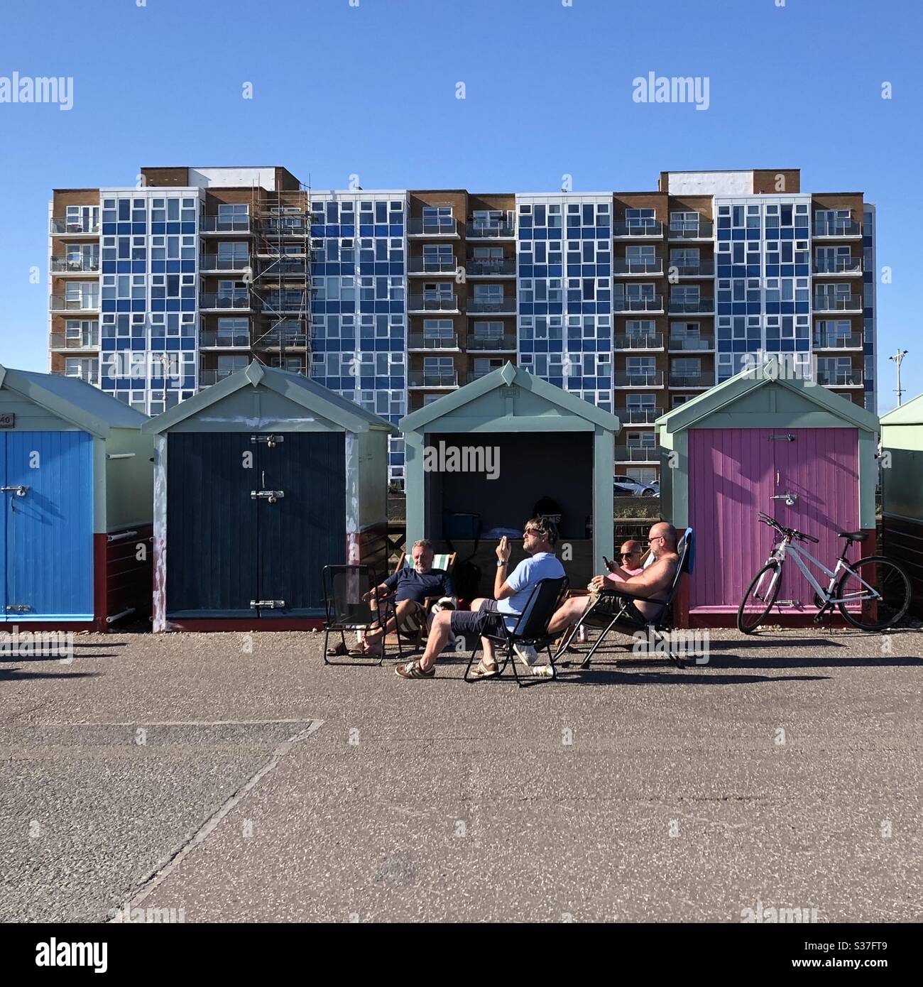 Kleine Gruppe von Freunden chillen auf Hove Waterfront in East Sussex, Großbritannien, Mitte Sommer während COVID-19 Pandemie. - Smartphone-aufgenommenes Stockfoto