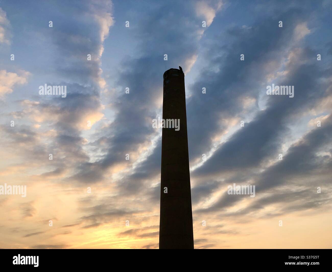 Hoher Kamin Smokestack bei Sonnenaufgang Stockfoto