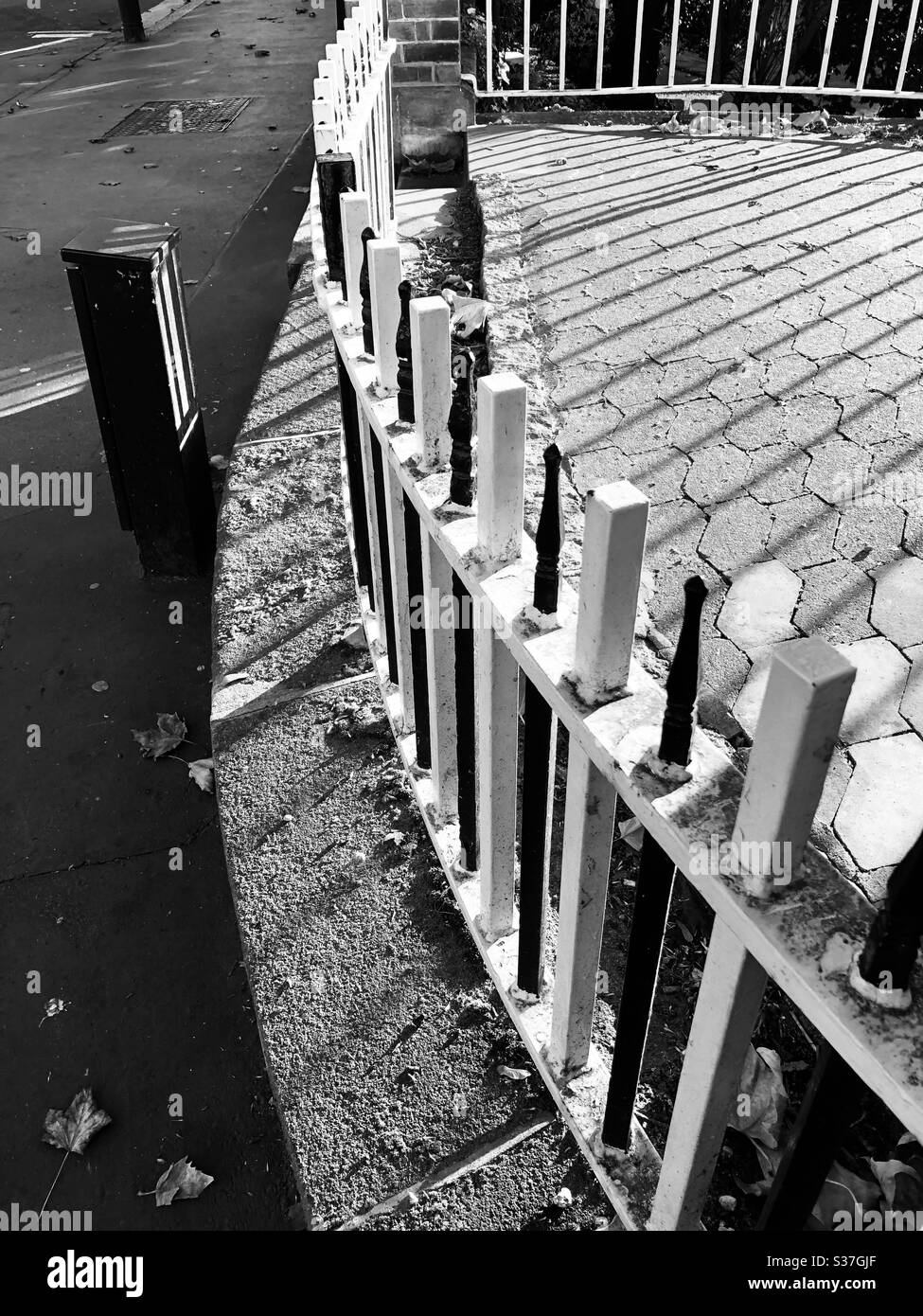 Schwarz-weiße Geländer mit markanten geometrischen Schatten Stockfoto