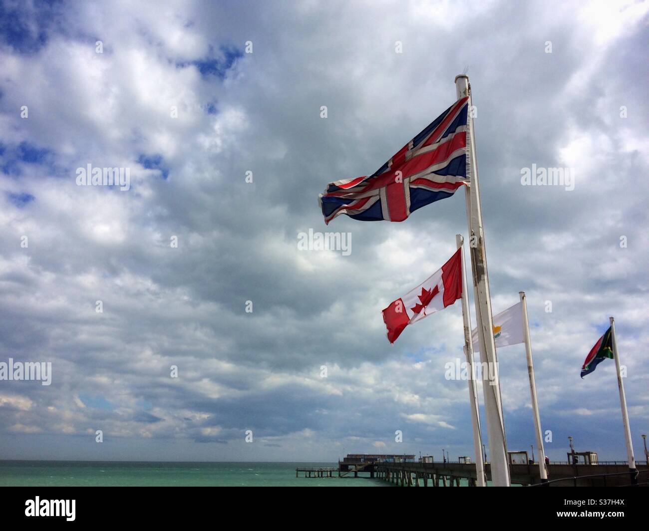 Die britische Union Jack Flagge, die neben der kanadischen Flagge am Eingang zum Pier bei Deal Kent UK fliegt Stockfoto