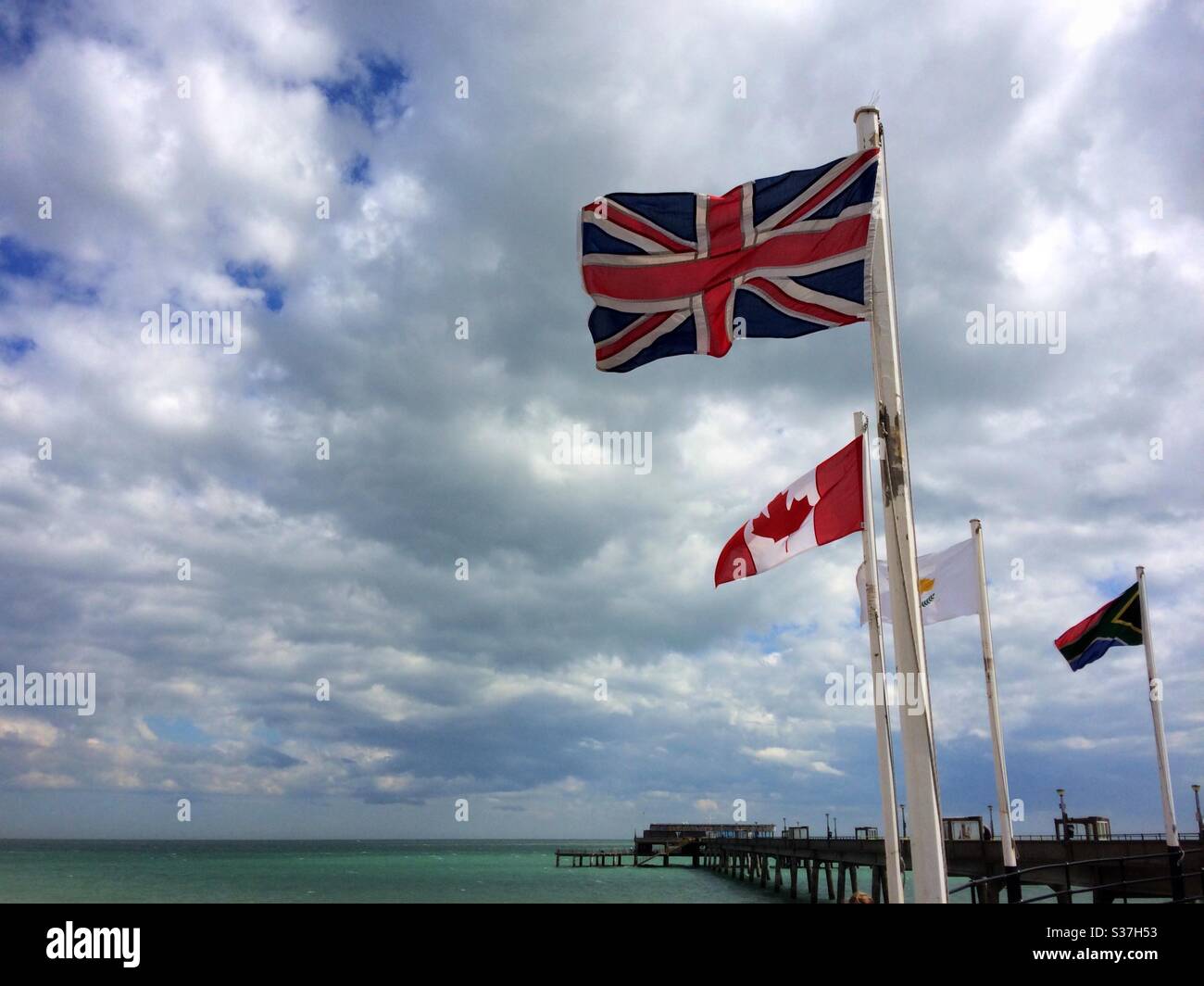 Die Union Jack, kanadische und südafrikanische Flaggen fliegen am Eingang zum Pier im Deal Kent UK Stockfoto