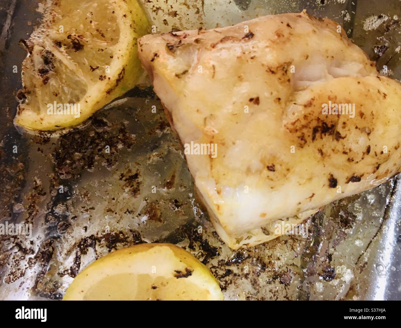 Im Ofen gebackener Rotschnapper Fisch mit Butterkräutern und Zitrone in einer Glasofenform Stockfoto