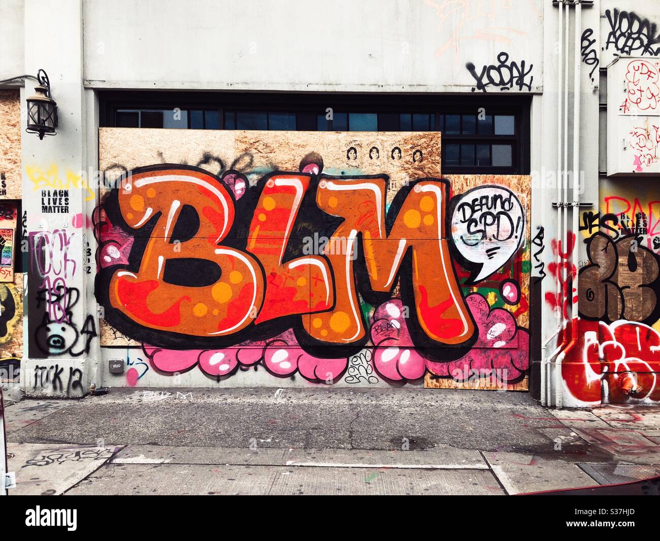 Graffiti BLM Briefe auf einem vernagelten Fenster auf einer Straße in CHAZ CHOP autonome Zone auf Capitol Hill in Seattle, Juni 2020 Stockfoto