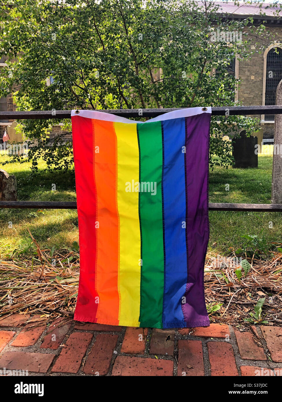 Regenbogenfahne vor einer Kirche für den Pride Month, um die Rechte der LGBTQ zu unterstützen Stockfoto