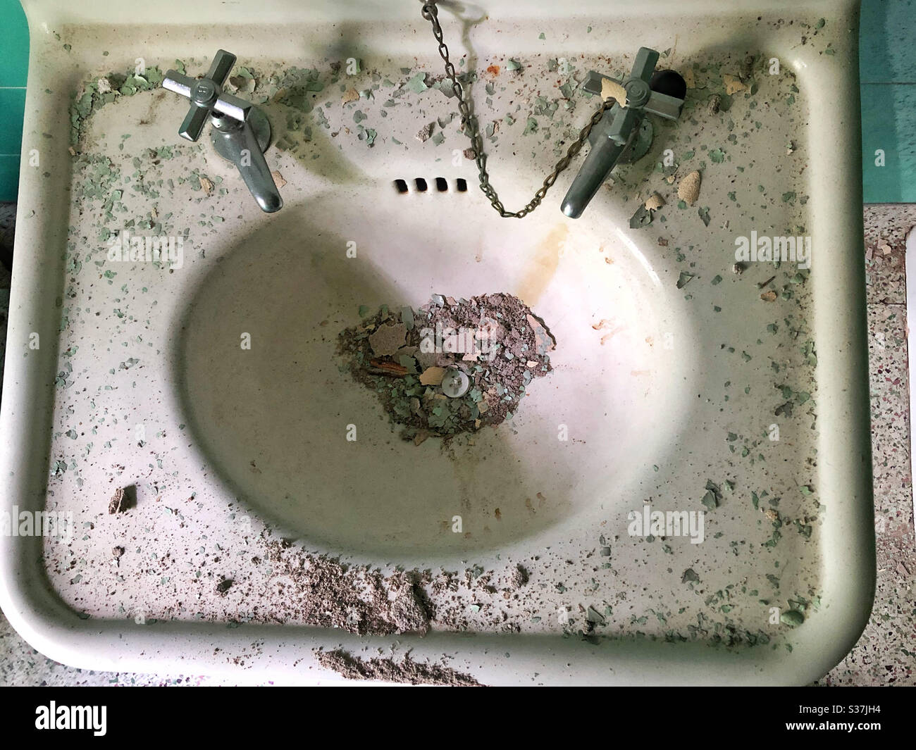 Waschbecken in verlassenen Haus, mit Farbspäne und Putzreste, die im Laufe der Zeit angesiedelt haben Stockfoto