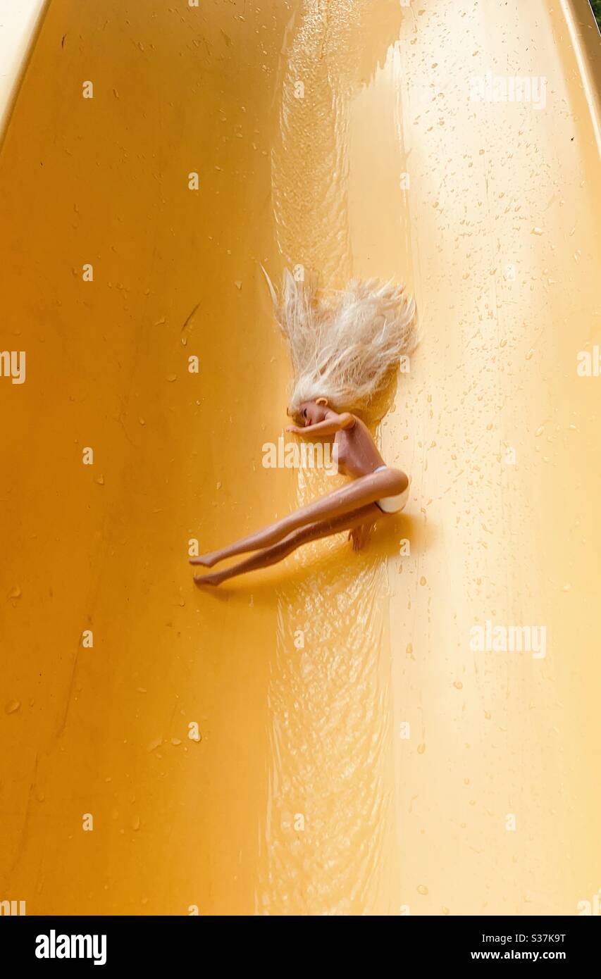 Barbie rutscht nach unten eine gelbe Wasserrutsche im Sommer  Stockfotografie - Alamy