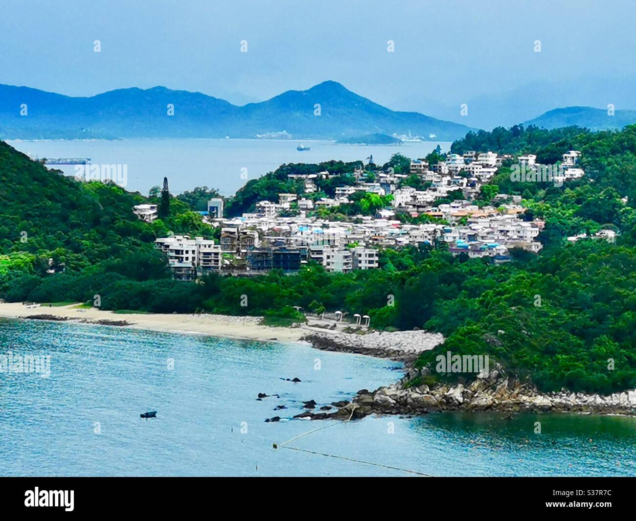 Ein Blick auf Yung shue wan und die umliegenden Dörfer auf der Lamma Insel mit der Insel Lantau im Hintergrund. Stockfoto