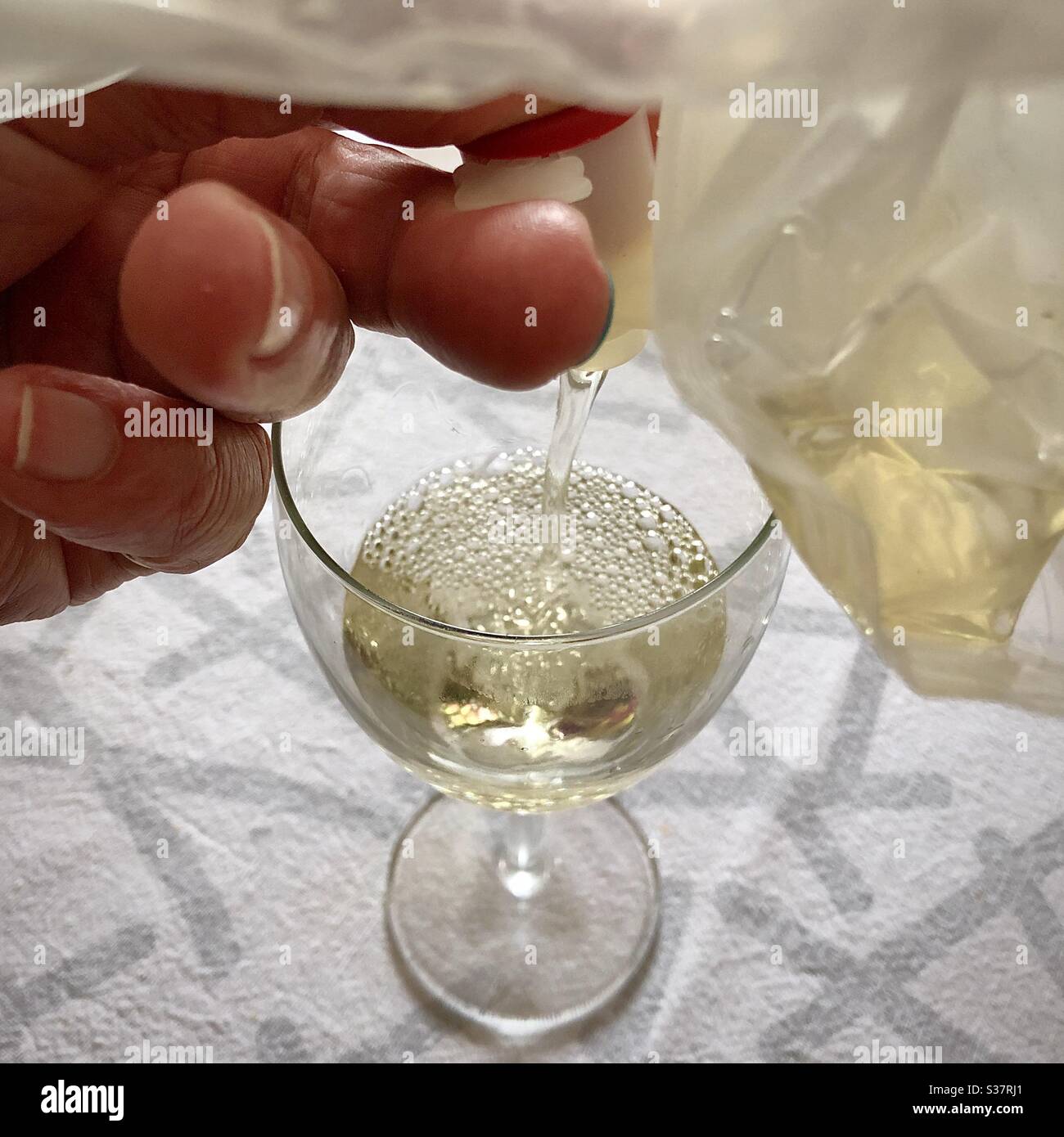 Gießen letzte Tropfen Weißwein aus Plastiktüte aus der Schachtel Wein. Stockfoto