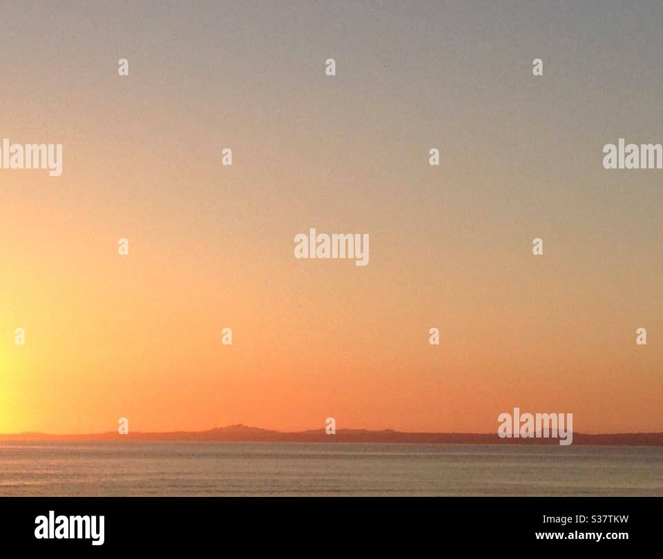 Kopieren Sie das Weltraumbild eines hellen Sonnenuntergangs über dem Meer. Aufgenommen an der walisischen Küste. Ideal für Sympathie Karte oder Grußkarte Hintergrund Stockfoto